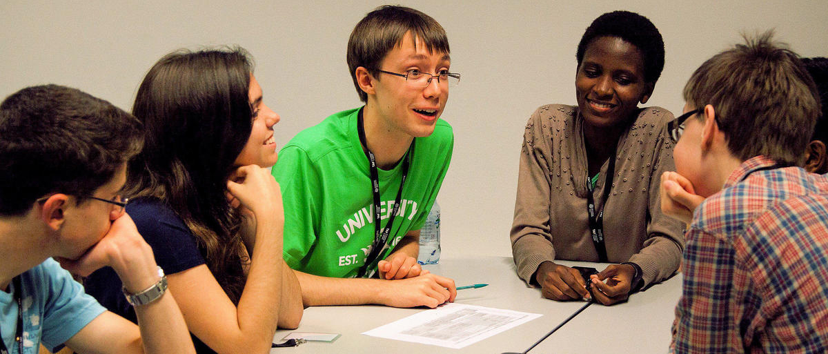 Joukko nuoria keskustelee yhdessä kansainvälisellä Global Challenges -leirillä. Leiri on esimerkki lukioikäisille suunnatusta toiminnasta