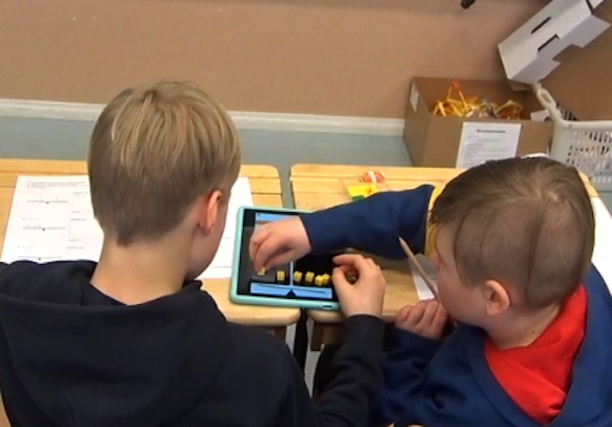 Kuva luokkainterventiosta, jossa oppilaat ratkaisi yhtälöitä kehitetyn välineen avulla vuorovaikutuksessa.