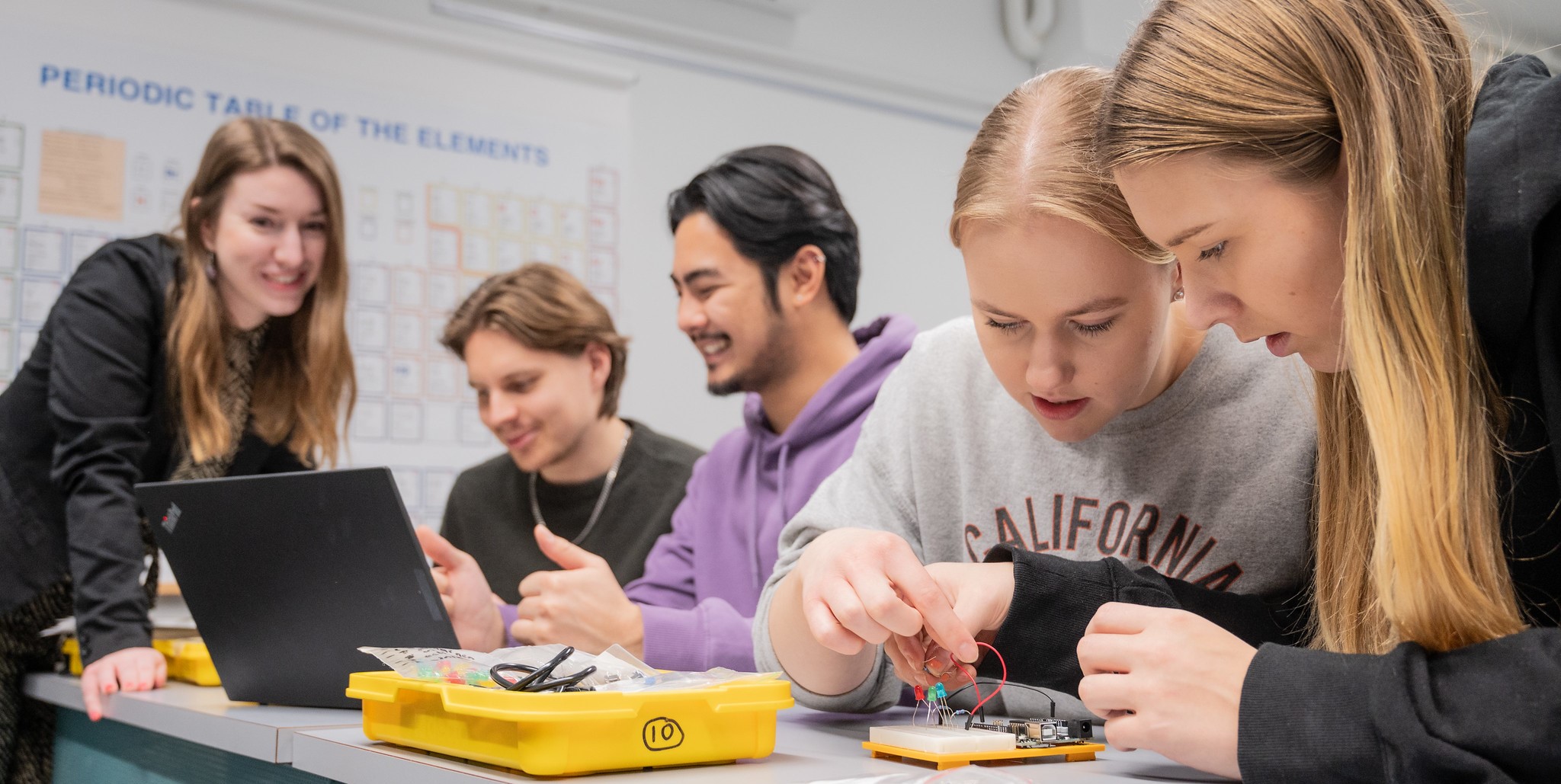 Kuvassa lukiolaiset tutkivat Arduino-välineitä opettajan johdolla.